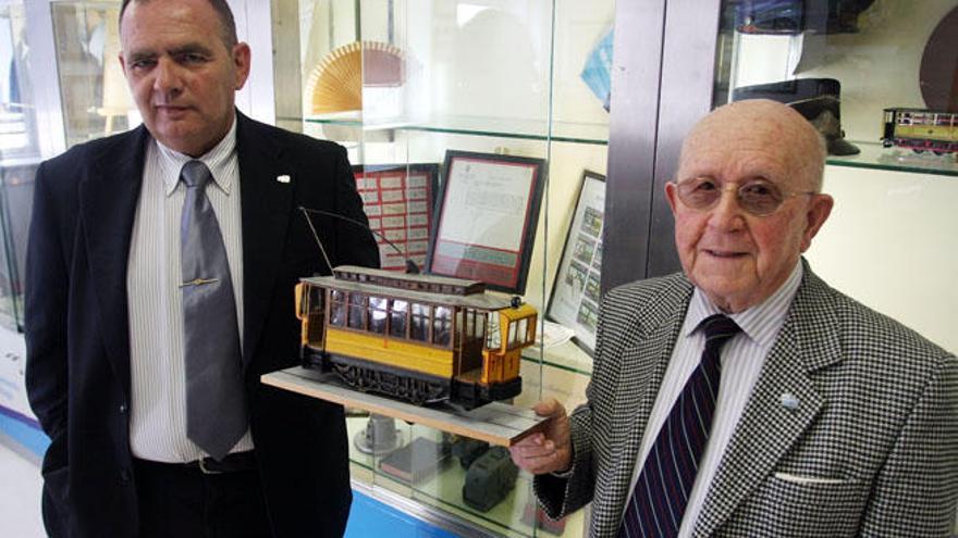 José Ramón Rodríguez, presidente de Tranbus, y el artista Salvador Cobos sostienen una maqueta del tranvía del Morlaco.