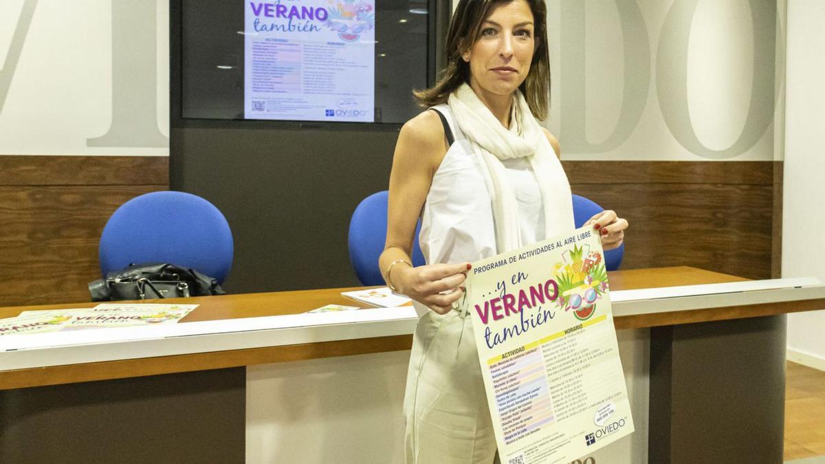 Lourdes García, con el cartel anunciador de las actividades estivales de los centros sociales. | Valentina Ciuca