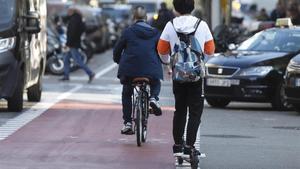 Un joven circula en patinete eléctrico por el carril bici de carrer Provença, en Barcelona.