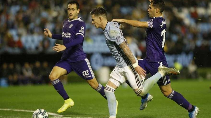 Santi Mina conduce el balón perseguido por dos jugadores del Valladolid, el viernes pasado. // R. Grobas