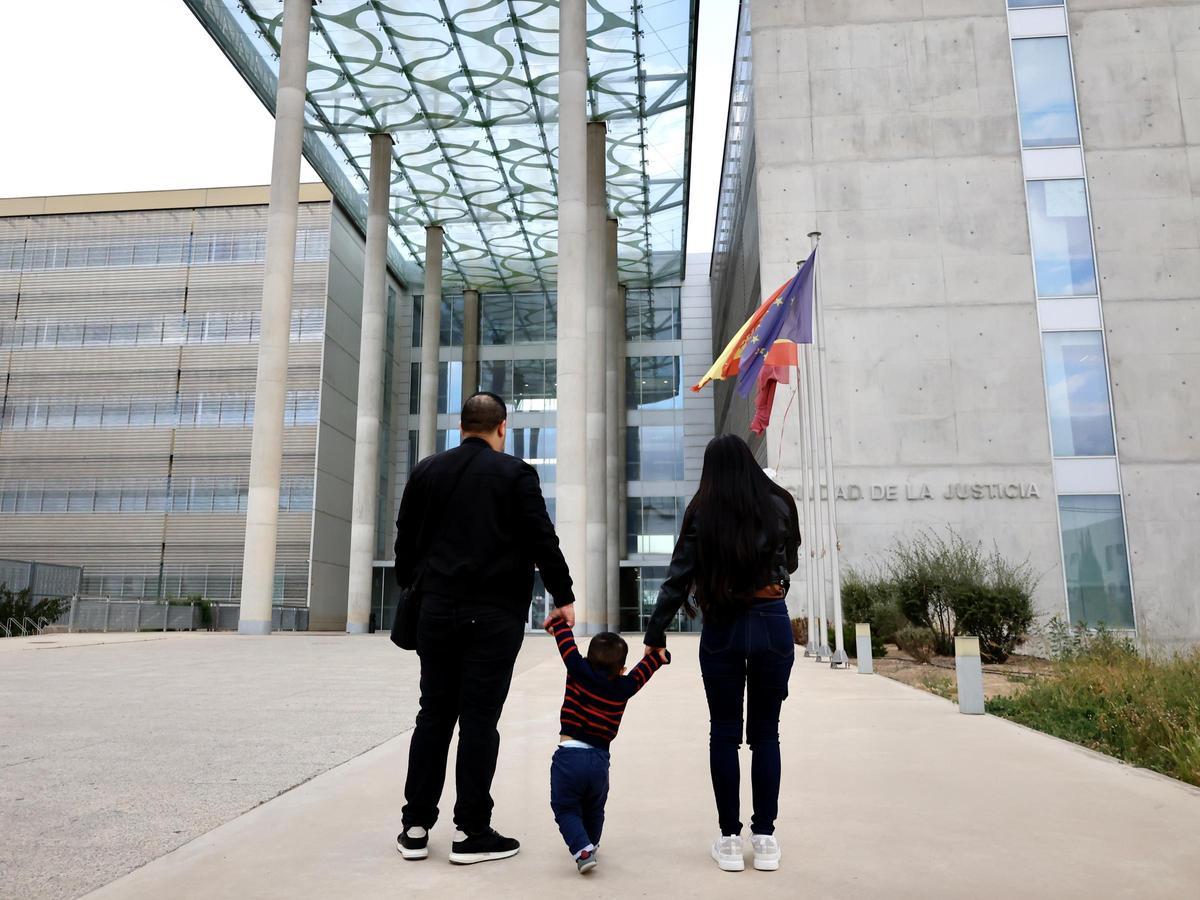 El pequeño Mikel, con sus padres, este lunes en el exterior de la Ciudad de la Justicia de Murcia, donde está el Registro Civil.