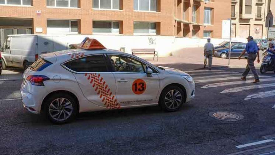 Un vehículo de una autoescuela local parado ante el paso de un peatón en El Ferial.