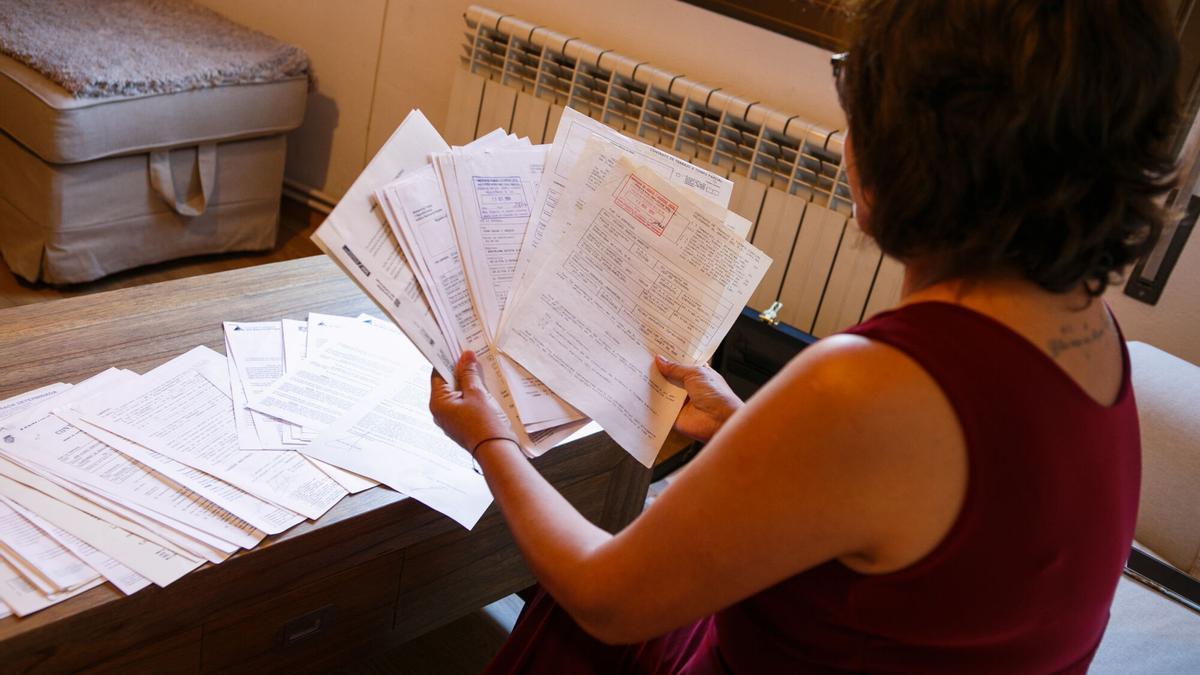 Una mujer mostrando todos los contratos de su vida laboral (Montcada i Reixach).
