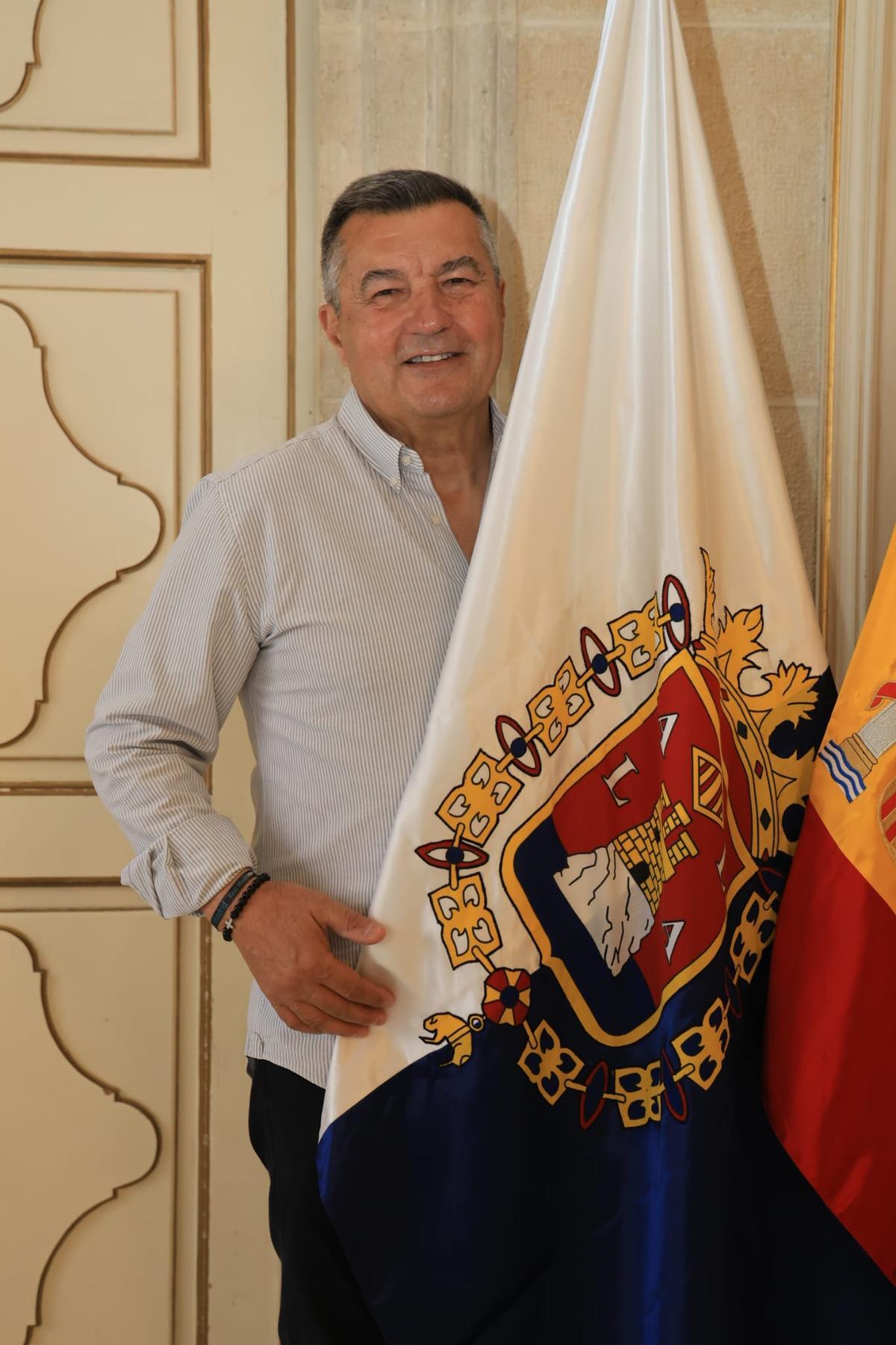 Andrés Llorens, presidente de la comisión del Centenario de las Hogueras, con la bandera de Alicante.
