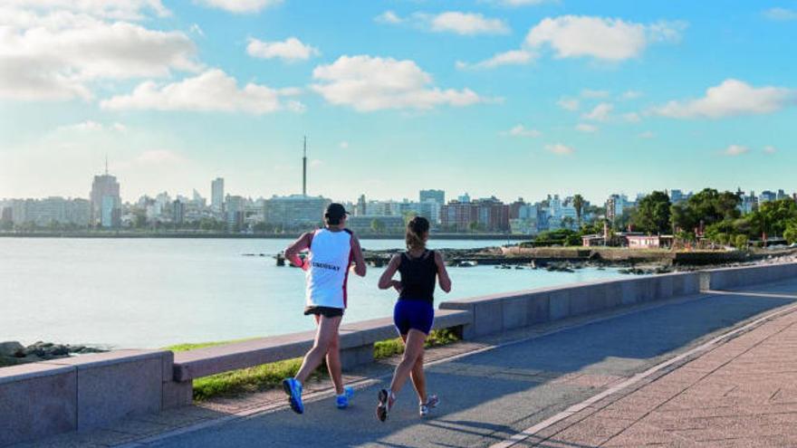 Una pareja de uruguayos corre por el paseo marítimo de la capital, Montevideo.