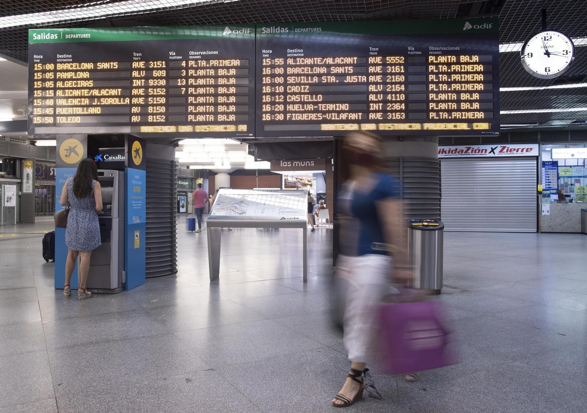 Archivo - Pasajeros en el panel de salidas de la estación de AVE de Atocha