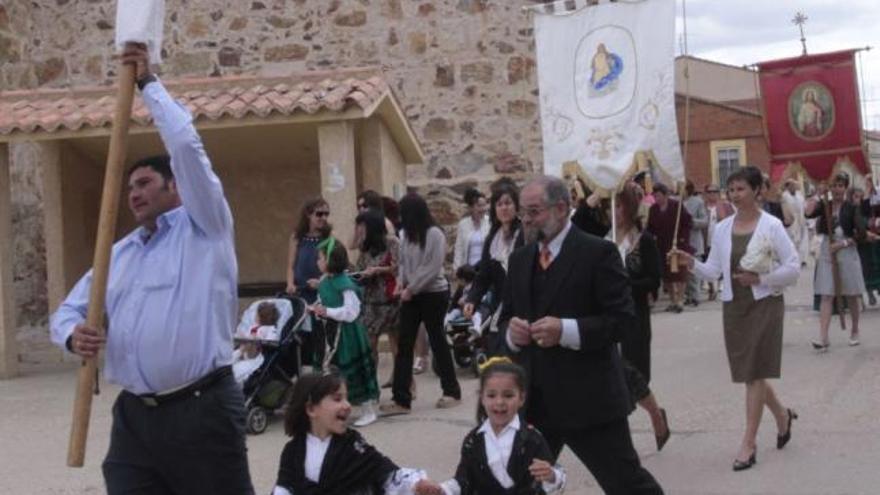 La cruz guía parroquial y los estandartes abren el desfile.