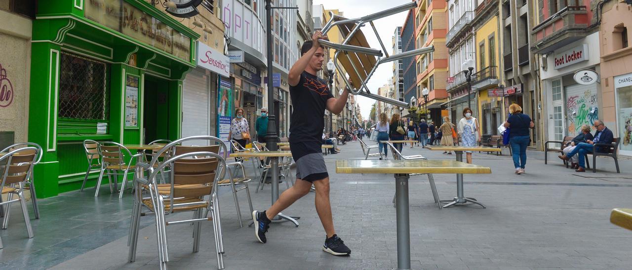 Un empleado coloca la terraza de un establecimiento hostelero de la capital grancanaria.