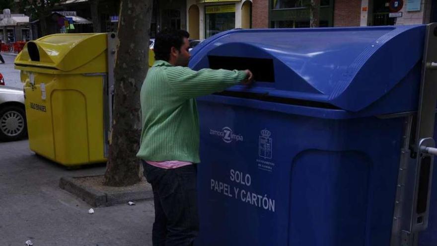 Un usuario deposita cartón en uno de los contenedores específicos de Tres Cruces.