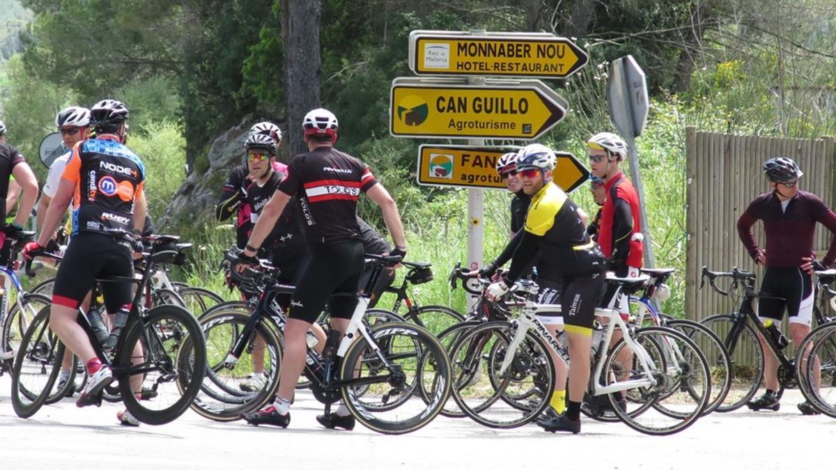 Un grupo de ciclistas en el cruce de la vieja carretera que lleva de Pollença as Campanet, en la isla de Mallorca