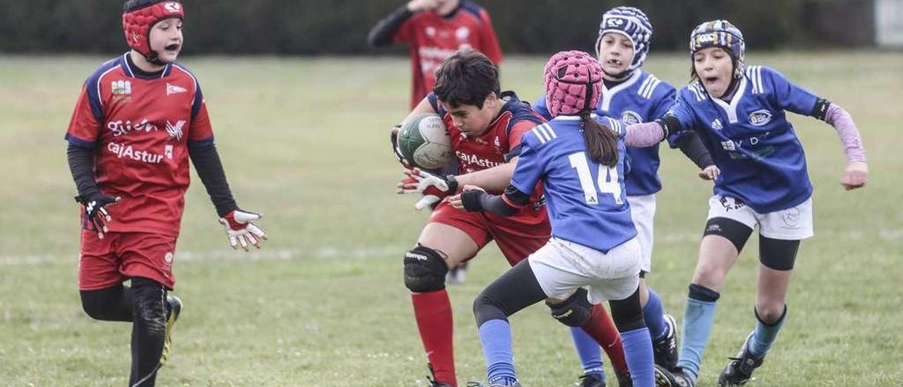 Un jugador del Cabueñes trata de avanzar ante la oposición de un rival del Oviedo Rugby.