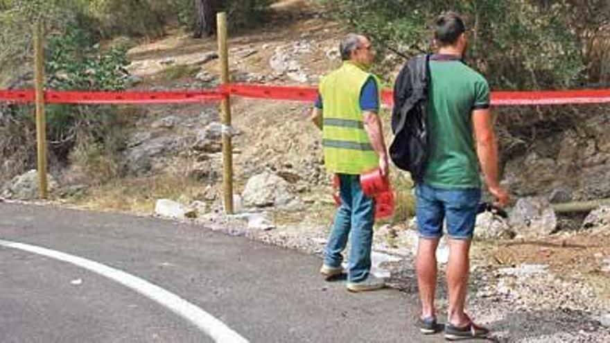 Miembros de la organización colocan cinta roja en la curva tras el siniestro.