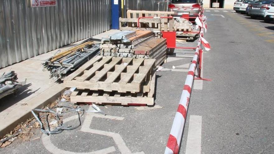 Plazas reservadas para personas con movilidad reducida en la calle Francisco Bejarano Robles, ocupadas con material de obra.