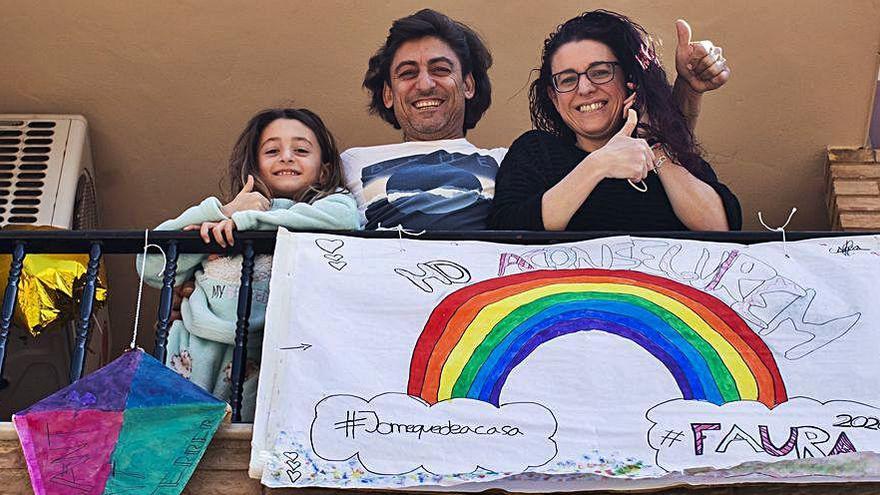 Una familia de Faura, con su cometa en el balcón y un optimista arco iris.