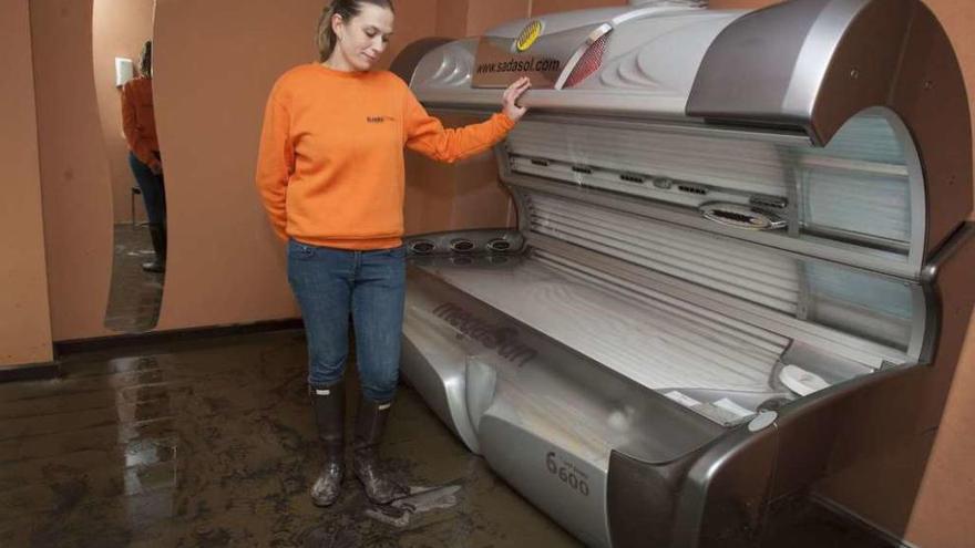 Una de las propietarias muestra una de las máquinas dañadas el día después de la inundación.