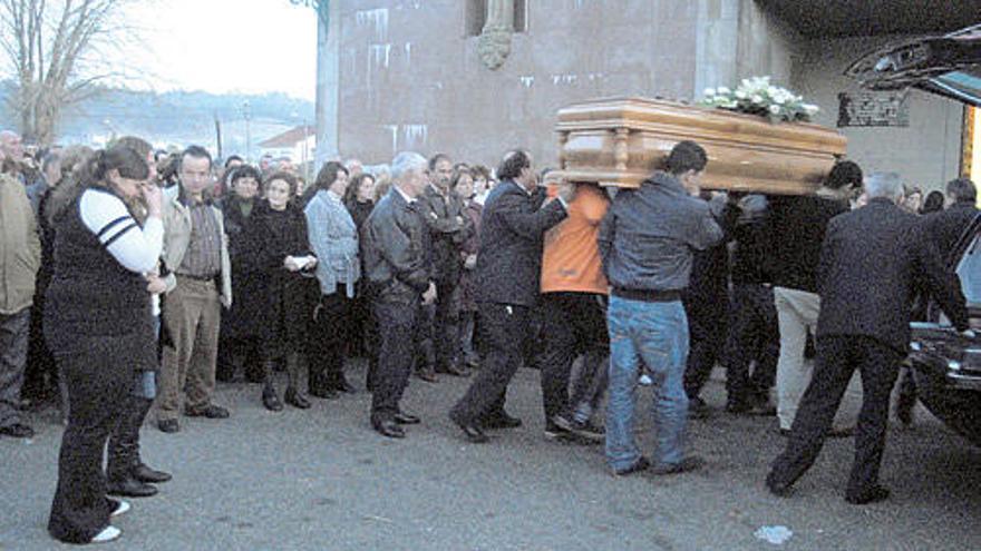 Cuatro de los hijos de Maricarmen Barcala trasladan el féretro a hombros a la entrada de la iglesia de San Pedro de Rubiáns.