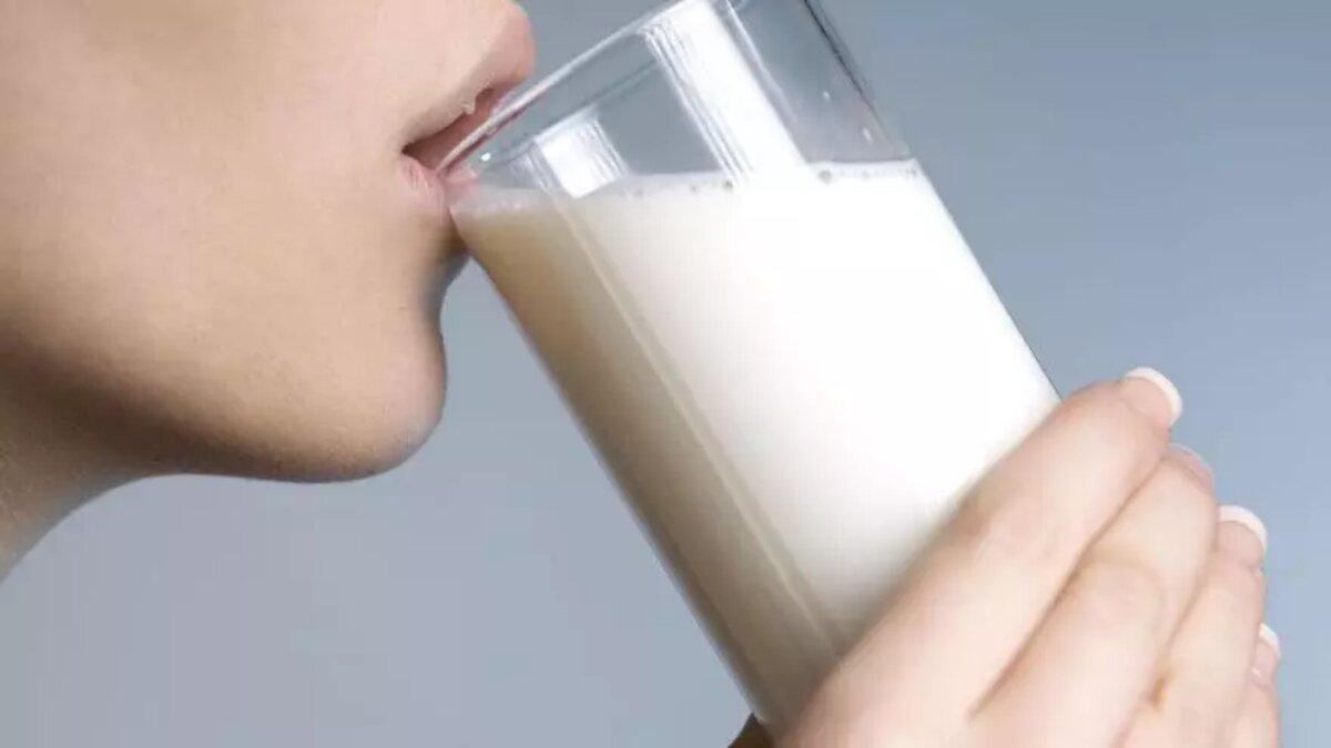 Una mujer bebe un vaso de leche
