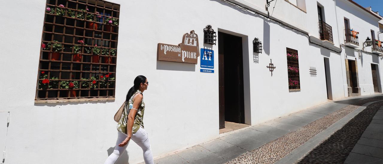 Una mujer camina ante la puerta de un apartamento turístico.