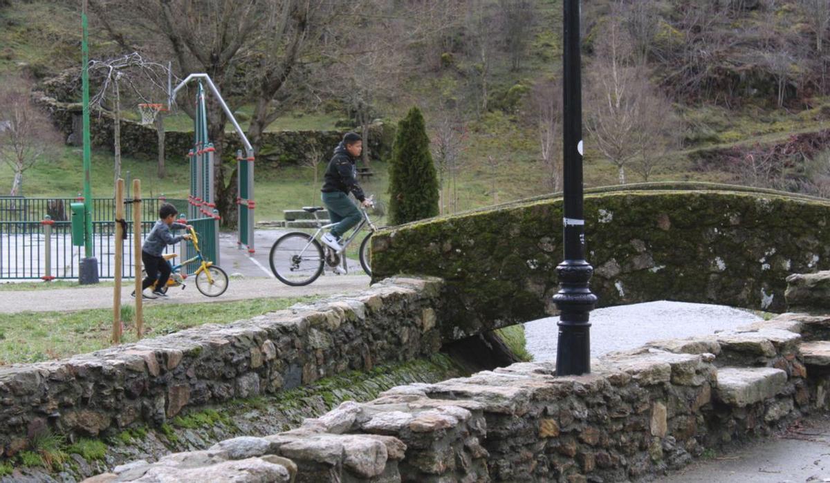 Ángel y su tío Keiler recorren el pueblo de Porto de Sanabria en bicicleta. | A. S.