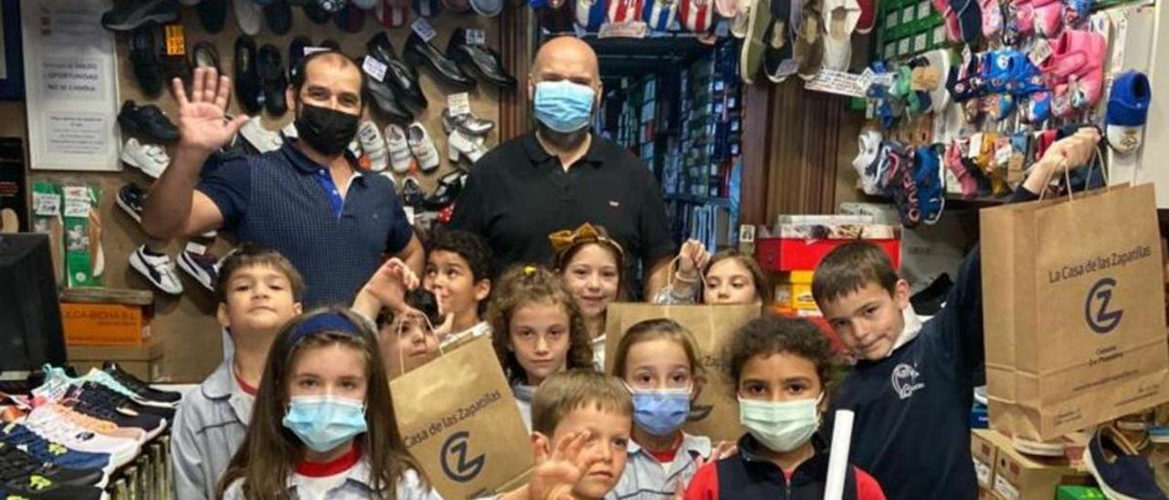 Alumnos de la Grande Obra de Atocha recaudan artículos para la tómbola en los comercios del barrio