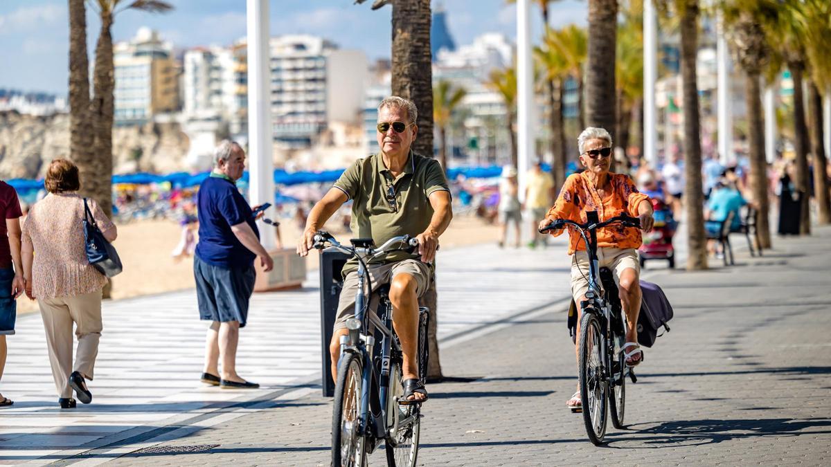 Ciclistas por la primera línea de playa de Benidorm este jueves.