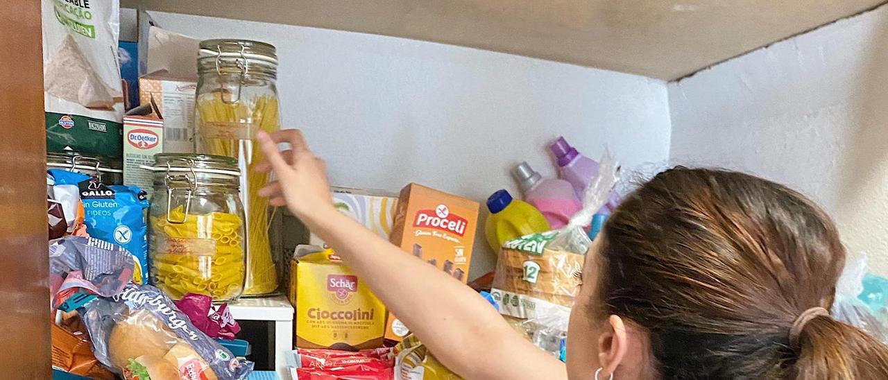 Ángela Villar coge un bote de pasta de su despensa.