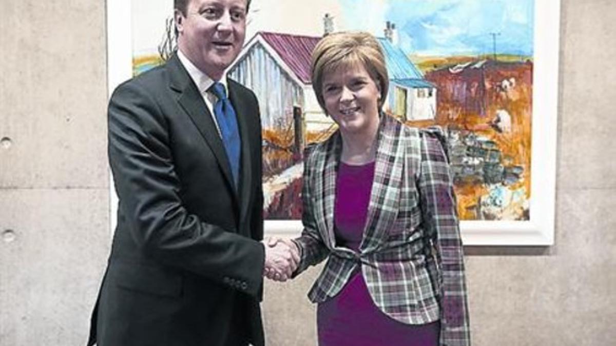 Cameron junto a Sturgeon este jueves en el Parlamento Escocés.