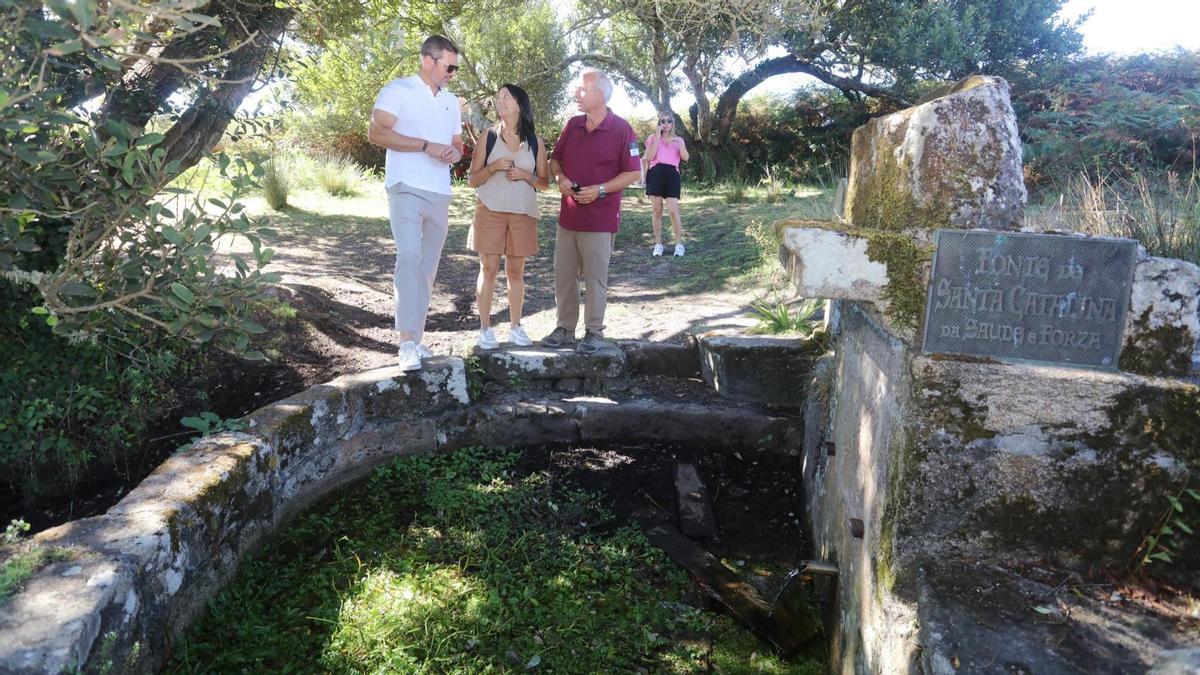 José López Campos, izquierda, con María Sampedro y José Antonio Fernández Bouzas, en la fuente de Santa Catalina de la isla de Sálvora.