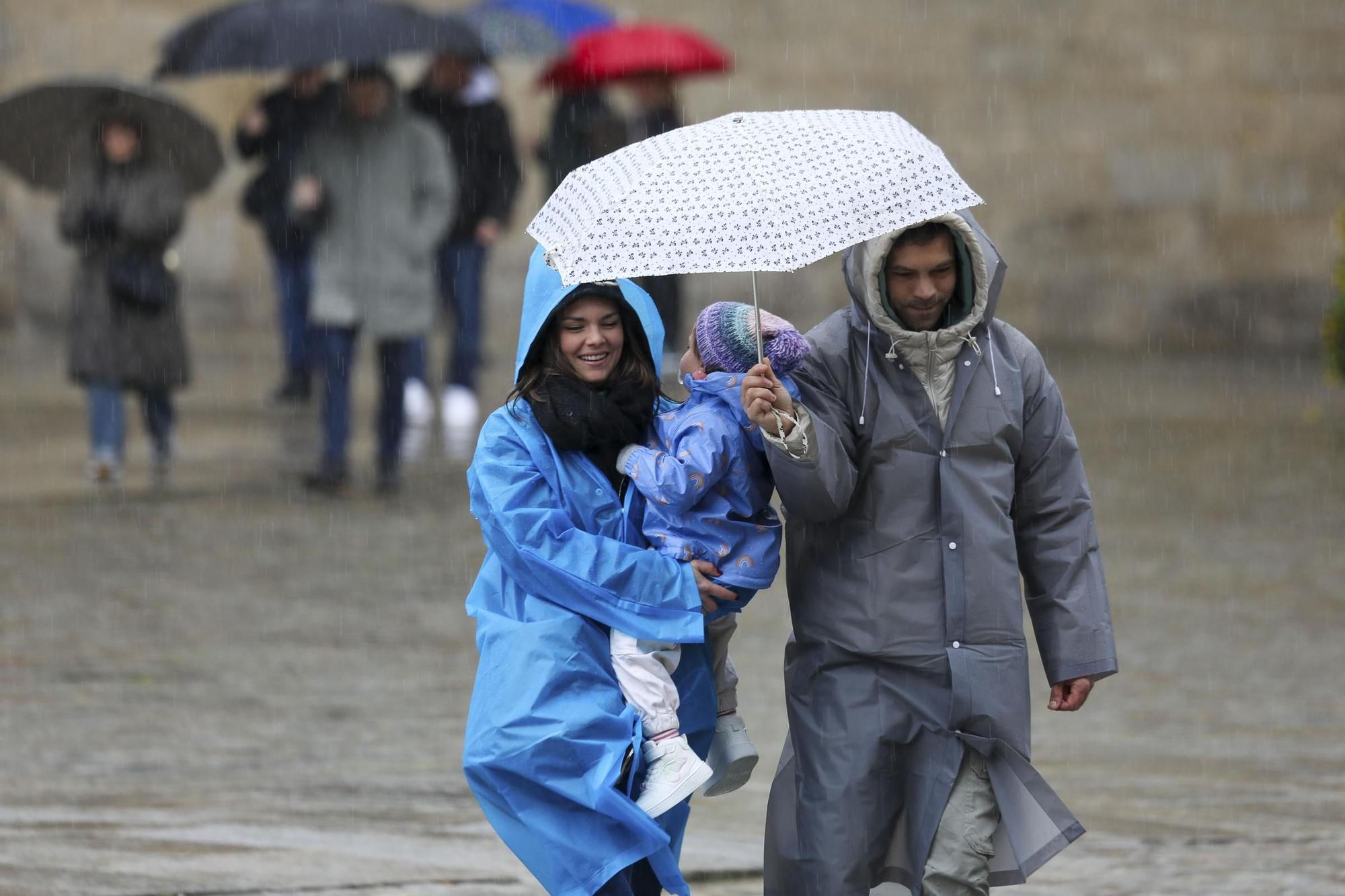 Visitantes bajo la lluvia en la Praza do Obradoiro, en Santiago de Compostela