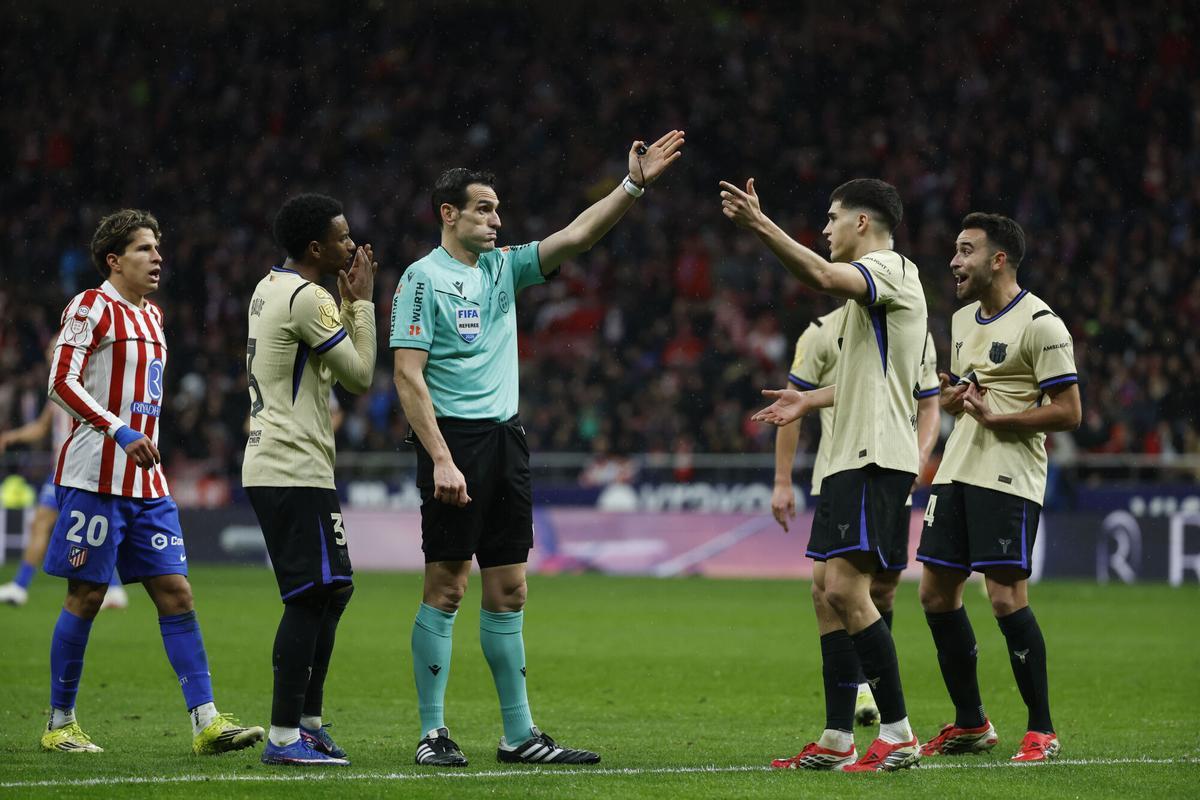 El árbitro Martínez Munuera señala una falta contra el Barcelona, durante el partido de ida de la semifinales de la Copa del Rey que Atlético de Madrid y FC Barcelona disputan este jueves en el estadio Metropolitano, en Madrid