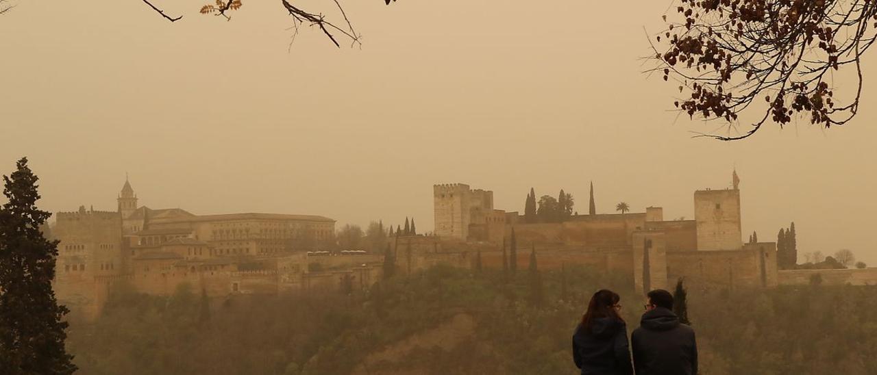 Crisis climática  España, cada vez más expuesta a las tormentas de polvo El aumento global de las sequías inunda la atmósfera de partículas en suspensión y alimenta los episodios globales de calima  Dos personas observan la Alhambra de Granada desde el Mirador de San Nicolás durante el episodio de calima del pasado mes de marzo, uno de los más intensos registrados en las últimas décadas. Dos personas observan la Alhambra de Granada desde el Mirador de San Nicolás durante el episodio de calima del pasado mes de marzo.