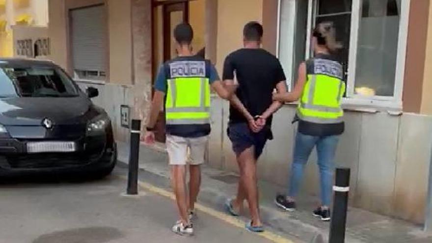 Agentes custodian a uno de los detenidos en la operación.