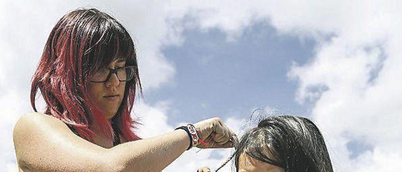 Laura Penedo hace una trenza a la alumna Lucía Domínguez.