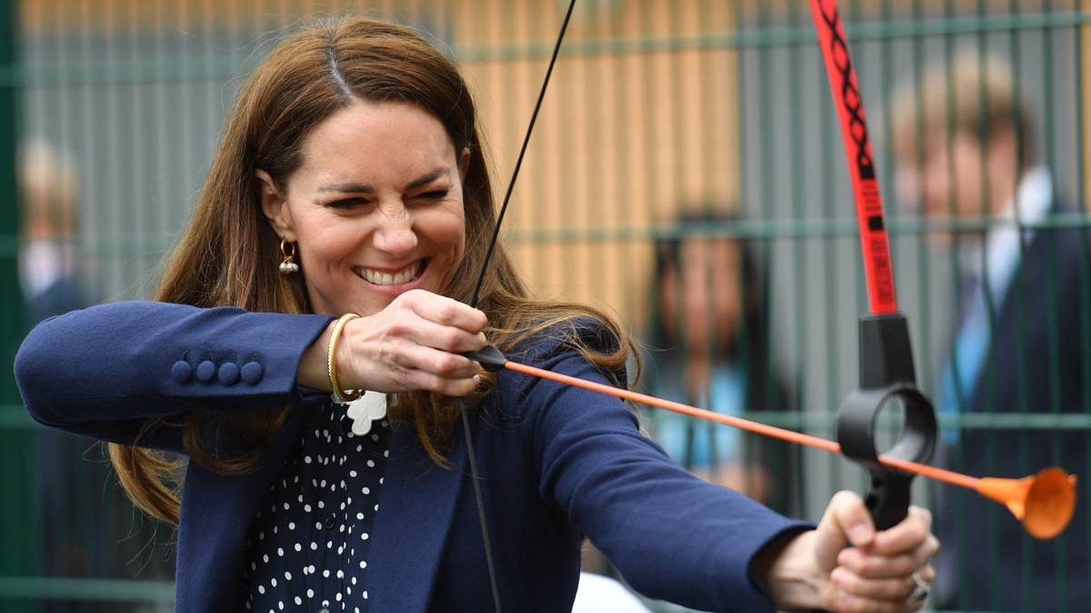 Kate Middleton pone a prueba su puntería con un arco y flechas. Va vestida con camisa de lunares