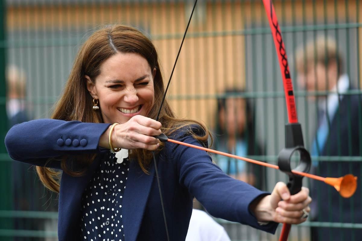 Kate Middleton pone a prueba su puntería con un arco y flechas. Va vestida con camisa de lunares