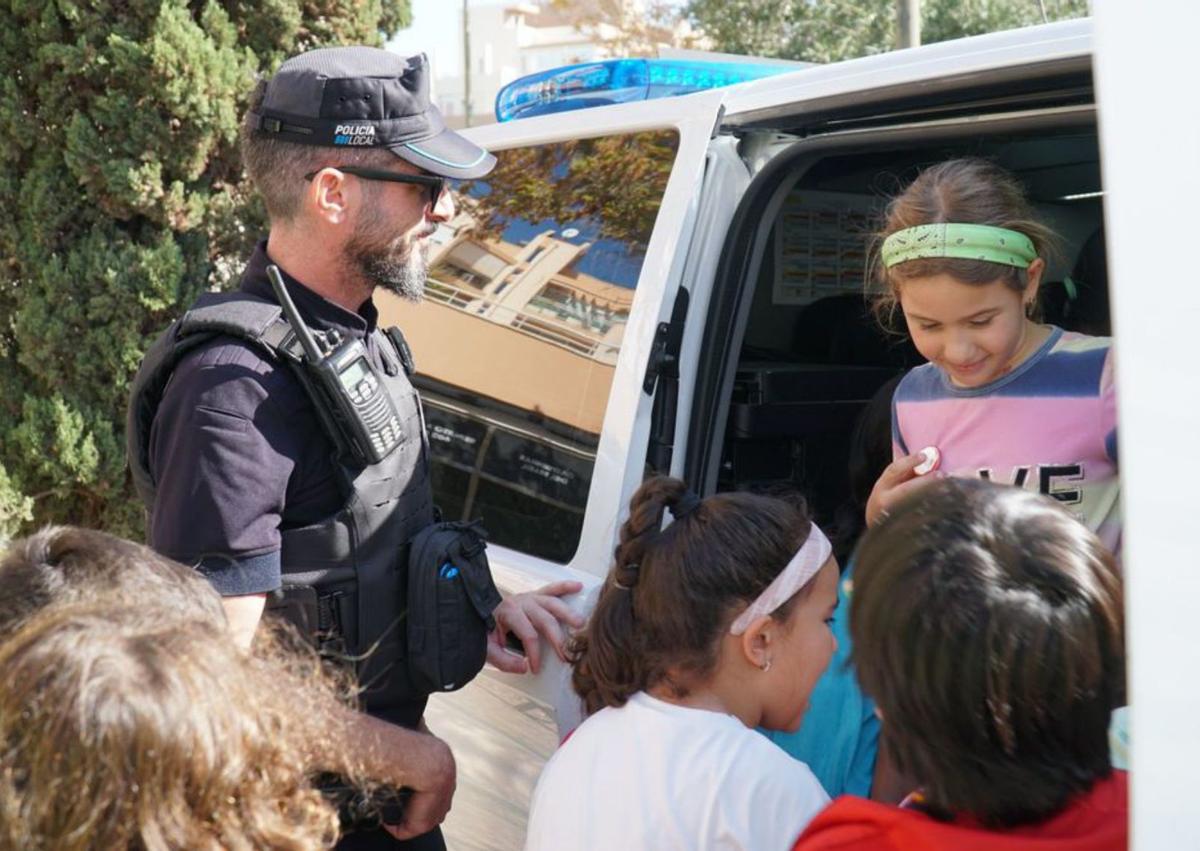 Los niños visitan el interior de un coche policial.  | A.E,.