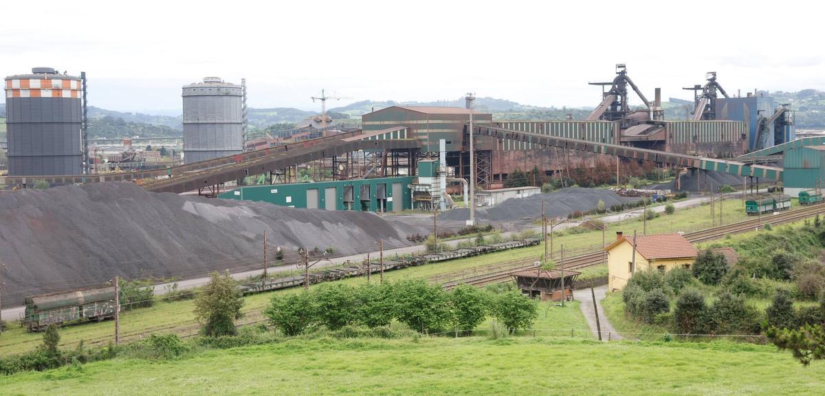 Acopios de mineral de hierro en las instalaciones de Arcelor, con los hornos altos a la derecha de la imagen.