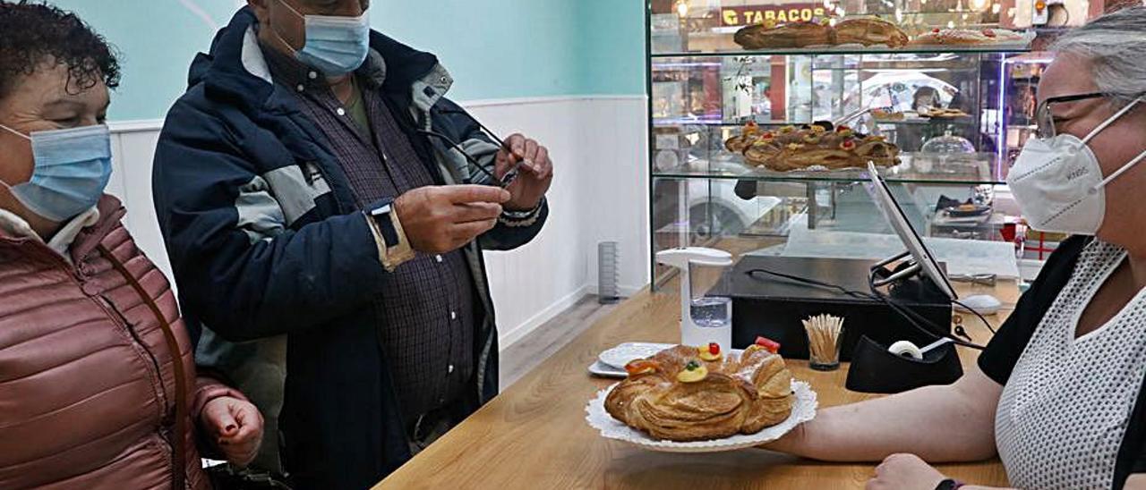 Celia Suárez enseña un roscón a Mina Fernández y Jorge Suárez.