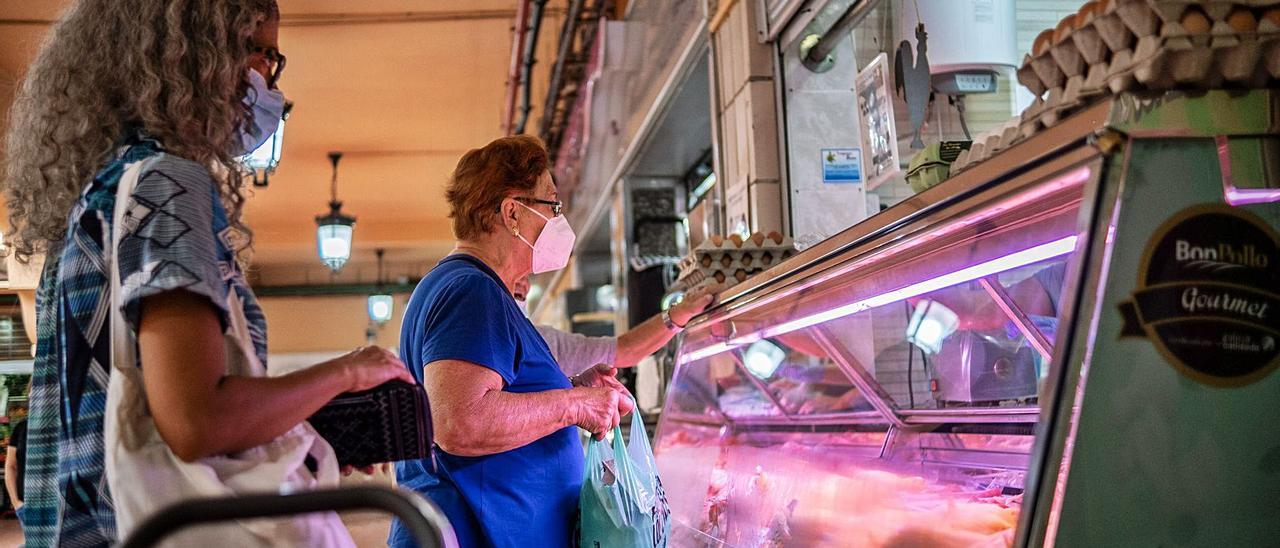 Una mujer compra en una carnicería del mercado.