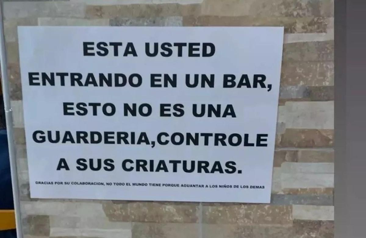 Cartel colgado en la entrada de un bar pidiendo vigilancia de los padres a sus hijos