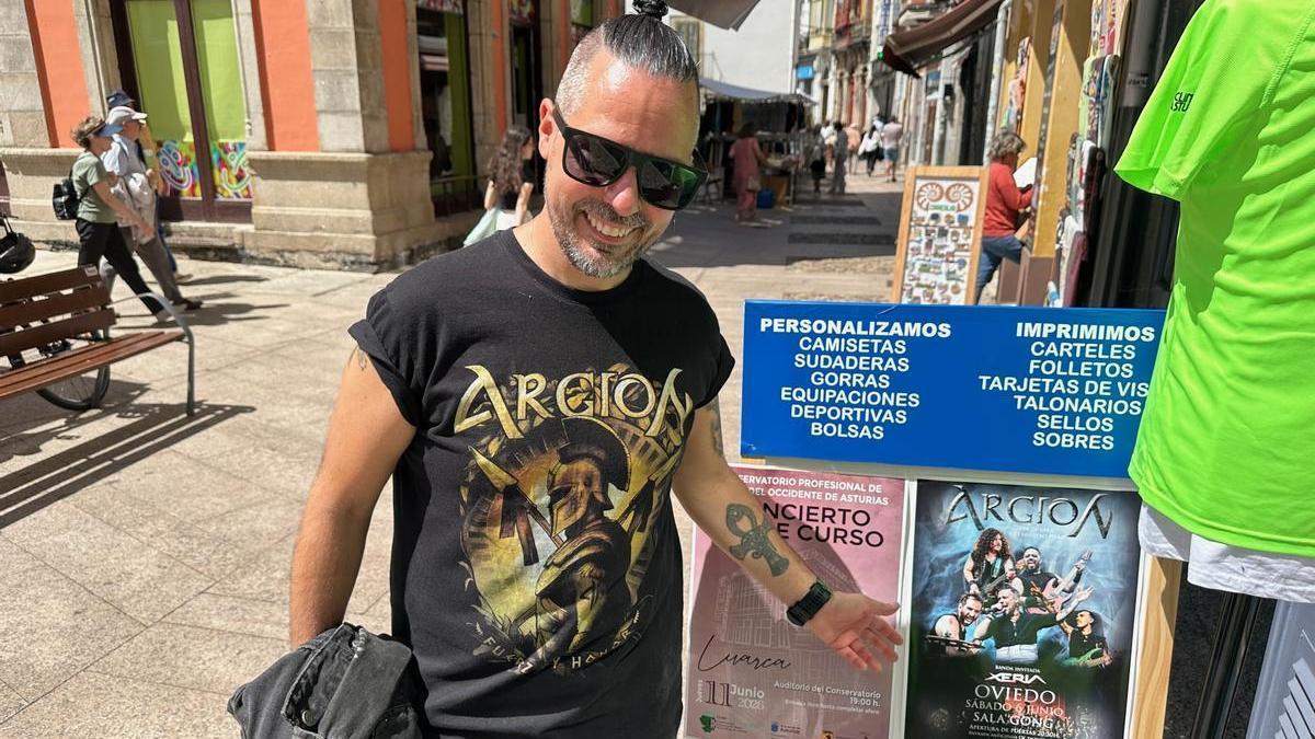 Richard de la Uz en Luarca, señalando un cartel de su próximo concierto.