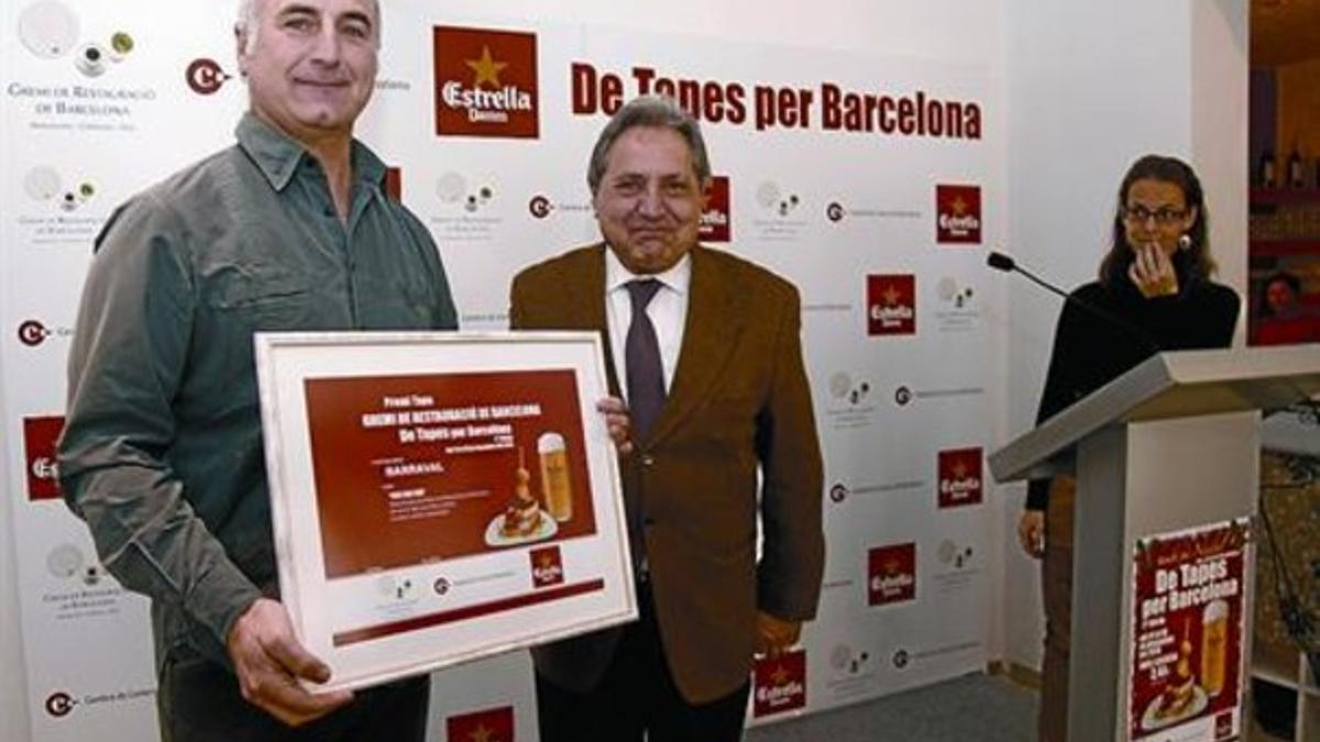 Gaietà Farràs, presidente del gremio de restauración, entrega el premio a un responsable del Barraval, ayer.