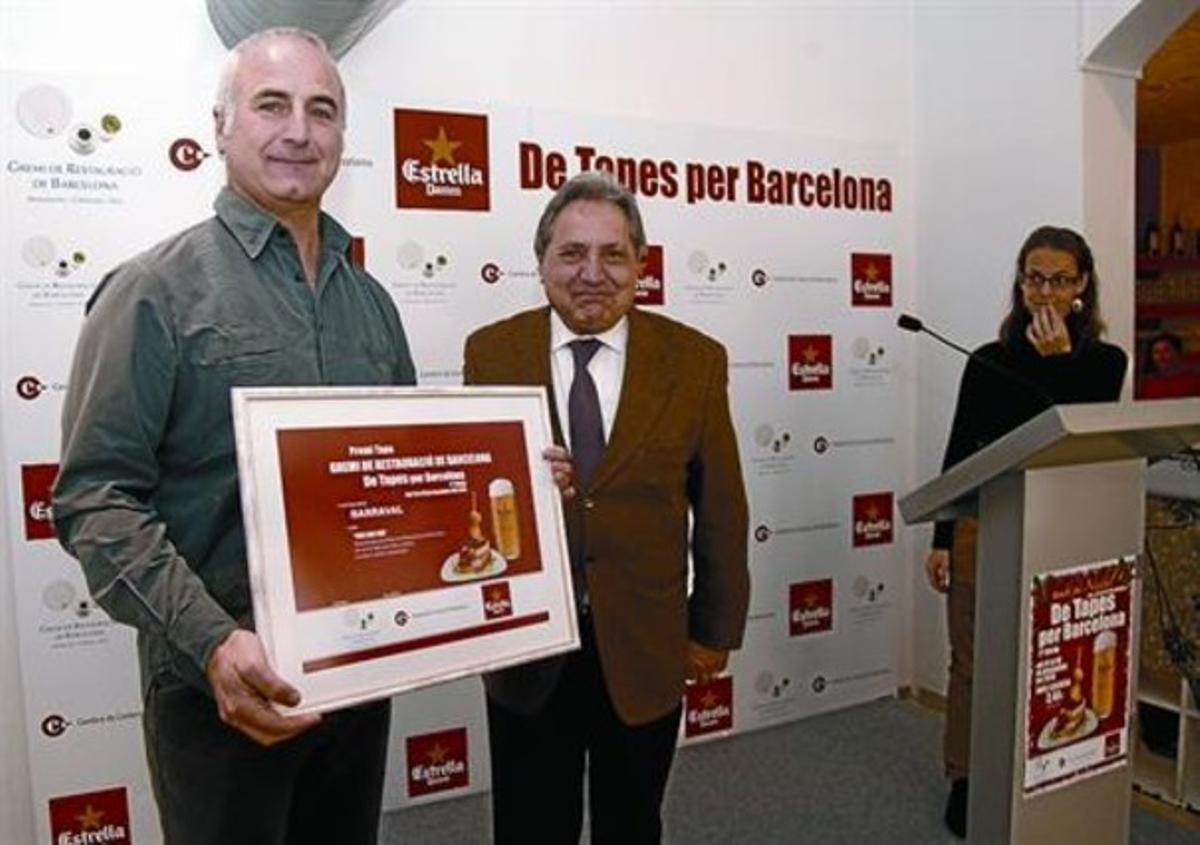 Gaietà Farràs, president del gremi de restauració, entrega el premi a un responsable del Barraval, ahir.