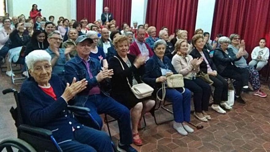 Los mayores asistentes al homenaje organizado por Cruz Roja aplauden la lectura de uno de los relatos dedicados a los abuelos