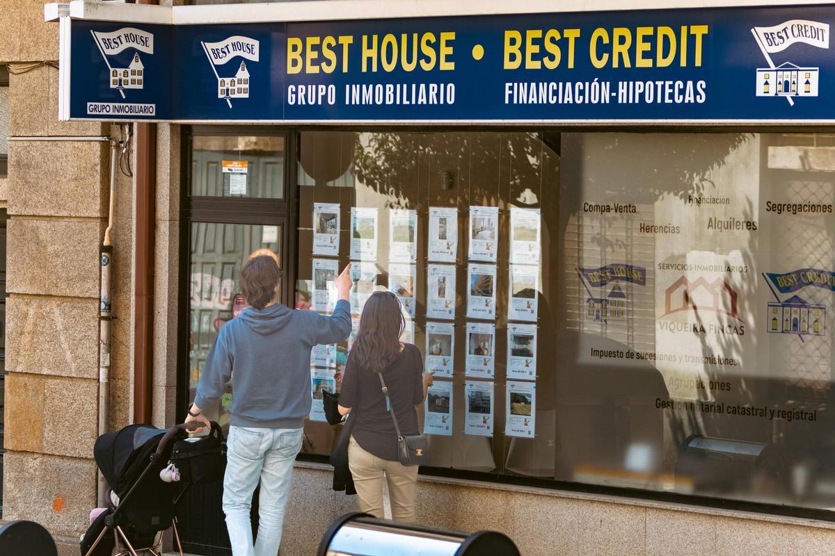 Una pareja observa los anuncios de viviendas en una inmobiliaria de Santiago.
