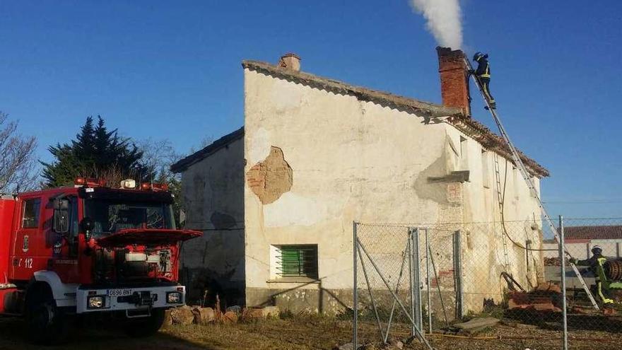 Los bomberos desplazados a Villager revisan la chimenea en la que se originó el fuego.