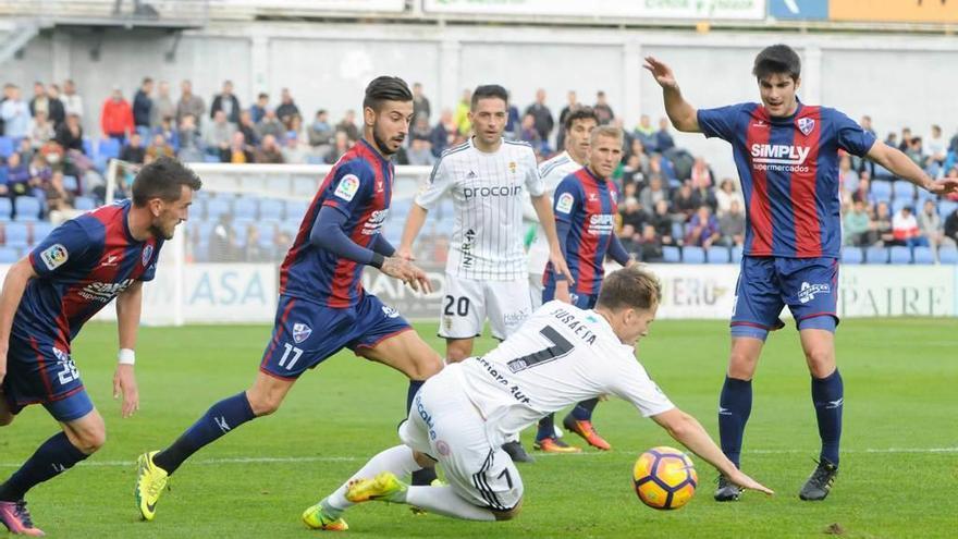 Susaeta cae al suelo ante la presión de los futbolistas del Huesca.