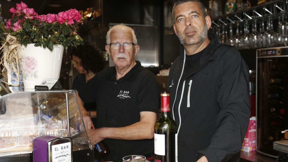 Pepe Bonet (c), bien arropado por sus hijos Silvia (i) y Emilio (d) en la barra del popular bar de El Mercat de Castelló.