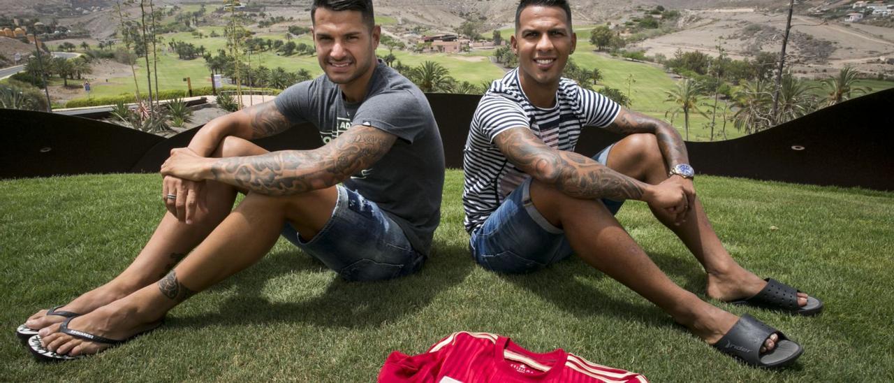 El extremo del Atlético de Madrid Víctor Machín Pérez ‘Vitolo’ (i) y el capitán de la UD Jonathan Viera posan en El Salobre, junto a la camisa de España en 2017.  | | QUIQUE CURBELO