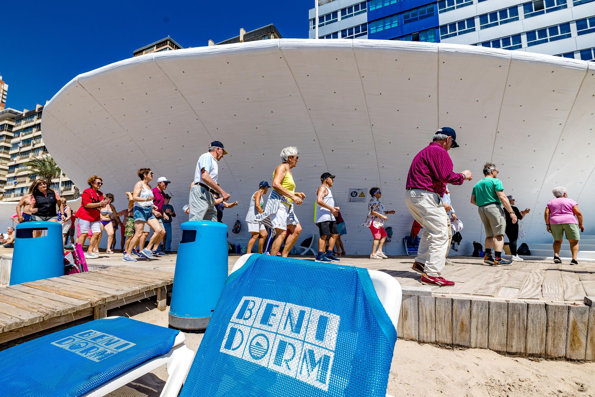 Un grupo de jubilados, en su mayoría turistas del Imserso, bailando en la playa de Poniente de Bendorm la pasada temporada de este programa.